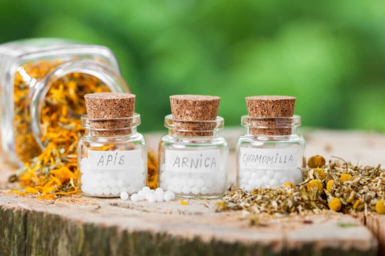 Ein paar Glasfläschchen gefüllt mit Arnica, Apis und Kamille Globuli in der Praxis von Heilpraktikerin Monika Tembrink in Hürth bei Köln