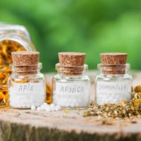 Ein paar Glasfläschchen gefüllt mit Arnica, Apis und Kamille Globuli in der Praxis von Heilpraktikerin Monika Tembrink in Hürth bei Köln