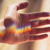 Hand mit Regenbogen in der Handfläche als symbolische Darstellung für helfende Hand in schweren Zeiten in der Naturheilpraxis für Bioenergetik in Hürth